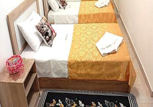 two twin beds in a room with a rug at Elias Home in Volos