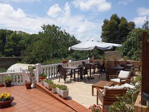 a patio with tables and chairs and an umbrella at Montañes in Santillana del Mar