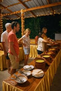 a group of people standing around a table with food at komalie resort in Kitulgala