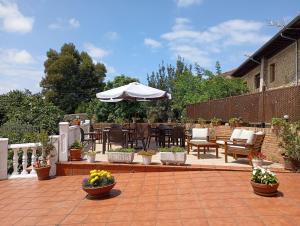 a patio with tables and chairs and an umbrella at Montañes in Santillana del Mar