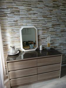 a dresser with a mirror on top of it at Gite les genêts in Le Vigeant +17 photos