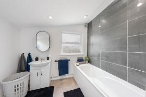 a bathroom with a white tub and a sink and a bath tub at 3Bd Cosy Home-Wifi-Pool Table- Gilly Hideaway in Gillingham