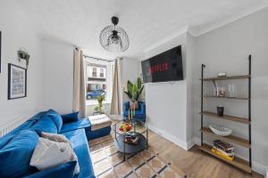 a living room with a blue couch and a tv at 3Bd Cosy Home-Wifi-Pool Table- Gilly Hideaway in Gillingham