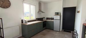 a kitchen with green cabinets and a white refrigerator at Logement 2 - proche Le Mans in Aigné