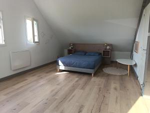 a bedroom with a blue bed and a table at Logement 2 - proche Le Mans in Aigné