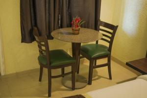 a table with two chairs and a table with flowers on it at Rani Palace Hotel And Resort in Kishangarh +22 photos