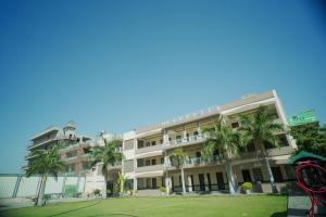 a large building with palm trees in front of it at Rani Palace Hotel And Resort in Kishangarh