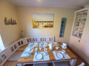 a dining room table with white dishes on it at Ferienhaus Ditzum am Sielblick in Ditzum