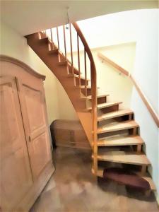 a wooden staircase in a room with a cabinet at Ferienhaus Ditzum am Sielblick in Ditzum +18 photos