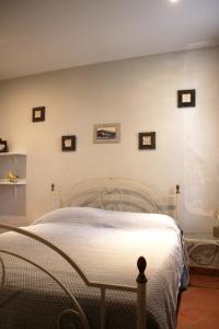 a bed in a room with pictures on the wall at Casa Cardinala in Gambellaro +33 photos