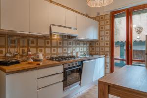 a kitchen with white cabinets and a stove top oven at Villa Chichizola in Rapallo +28 photos