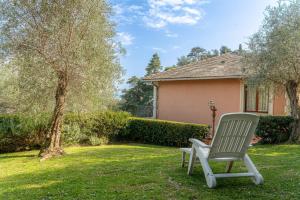 a chair sitting in the grass in front of a house at Villa Chichizola in Rapallo