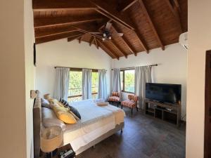 a bedroom with a bed and a flat screen tv at Estancia de Cafayate Wayra Huasi in Cafayate