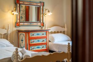 a bedroom with two beds and a dresser with a mirror at Villa Chichizola in Rapallo