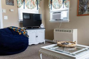 a living room with a tv and a glass table at Our Little Yellow House in Saint Anthony