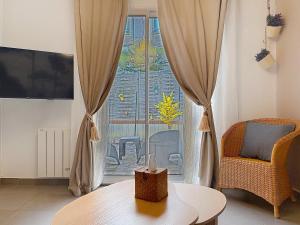 a living room with a table and a window at La Courette des Rois - Hyper centre & Chateau in Dourdan