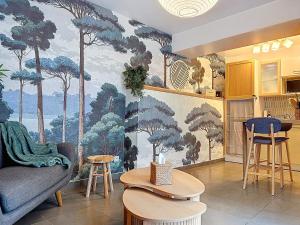 a living room with a wall mural of trees at La Courette des Rois - Hyper centre & Chateau in Dourdan
