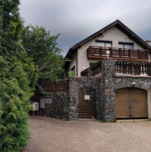 a house with a garage with a balcony on top at Chalet Sedmihori in Staré Sedlo