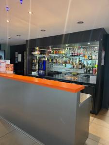 a bar with an orange counter in a restaurant at ibis Styles Flers in Flers +15 photos