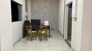 a table with two chairs and a computer on it at HotelItaveraMS in Campo Grande