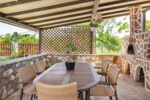 a wooden table and chairs on a patio at Villa Elysian Private pool & garden view in Antimácheia