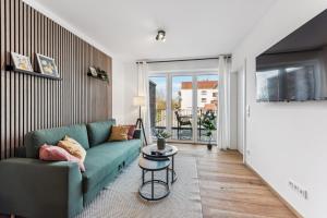 a living room with a green couch and a table at BohnApartments Dümmer See Suites, Top Lage 350 m zum See, Balkon, WLAN, Parkplatz in Lembruch