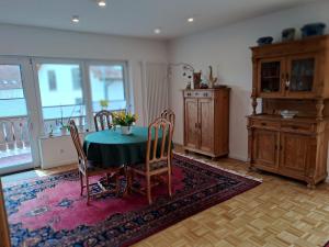 a dining room with a green table and chairs at Ferienhaus Ottilie in Gladenbach