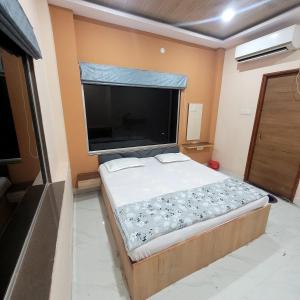 a bedroom with a large flat screen tv on the wall at The Rasoi Retreat in Majnān