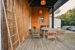 a wooden deck with a table and chairs on it at Maison Capucine in Hossegor