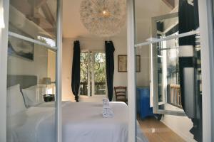 a bedroom with a white bed and a chandelier at Maison Capucine in Hossegor