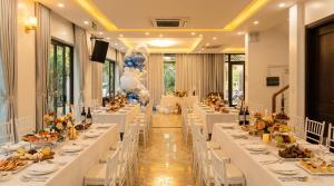 a banquet hall with tables set up for a wedding at Villa FLC Sầm Sơn Đức Anh in Sầm Sơn