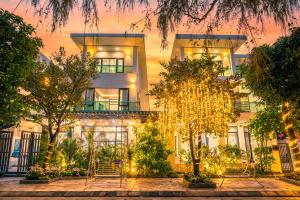a building with trees in front of it at Villa FLC Sầm Sơn Đức Anh in Sầm Sơn