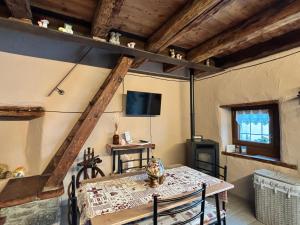 a dining room with a table and a television at La Casetta in Oyace