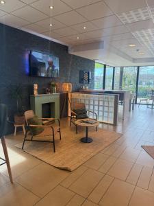 a lobby with chairs and a fireplace in a building at ibis Styles Flers in Flers