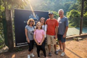 a family posing for a picture in front of a sign at komalie resort in Kitulgala