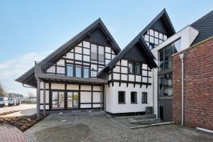 an exterior view of a house with black and white at BohnApartments Dümmer See Suites, Top Lage 350 m zum See, Balkon, WLAN, Parkplatz in Lembruch