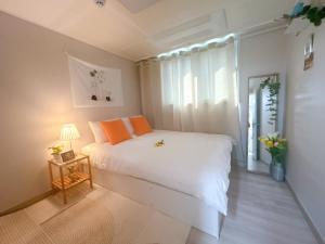 ein Schlafzimmer mit einem weißen Bett und einem Fenster in der Unterkunft Gate 303 in Seoul