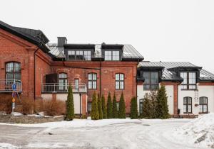 a large red brick building with trees in front of it at Modern Two-Bedroom Apartment with Sauna & Free Parking in Turku