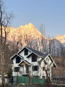 a white house with a mountain in the background at Dream River Resort in Batakūt +16 photos