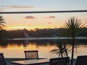 a table and chairs next to a lake with a sunset at Studio côté Canal Hossegor in Hossegor +2 photos