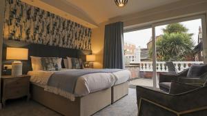 a bedroom with a bed and a chair and a window at Clifton Park Hotel - Adults Only in Lytham St Annes +61 photos
