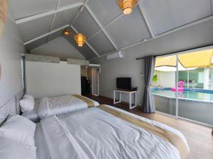 a bedroom with two beds and a swimming pool at Secret Terrace Pool Villa Rayong in Ban Bua Phut