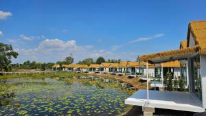 a row of houses with a pond of water lilies at Secret Terrace Pool Villa Rayong in Ban Bua Phut