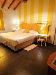 a bedroom with a large bed and a side table at Masoe des Chatards in Neuilly-le-Réal