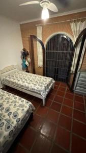 a room with two beds on a tiled floor at Pousada Realeza de Itanhaém in Itanhaém +2 photos