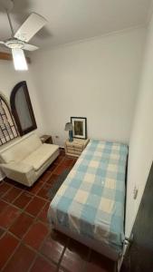 a bedroom with a bed and a couch in a room at Pousada Realeza de Itanhaém in Itanhaém