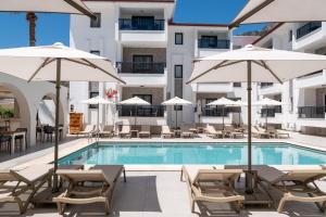 a pool with chairs and umbrellas next to a building at Diplomat Suites in Marmaris