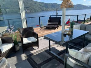a balcony with a table and chairs and a view of the water at Large house with panoramic sea view in Bergen