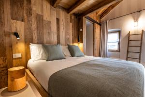 a bedroom with a large bed with wooden walls at Al Crotto in Chiavenna