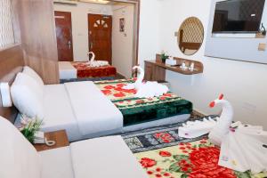 a hotel room with two beds and swans on the floor at Al Khaima Hotel in Dubai